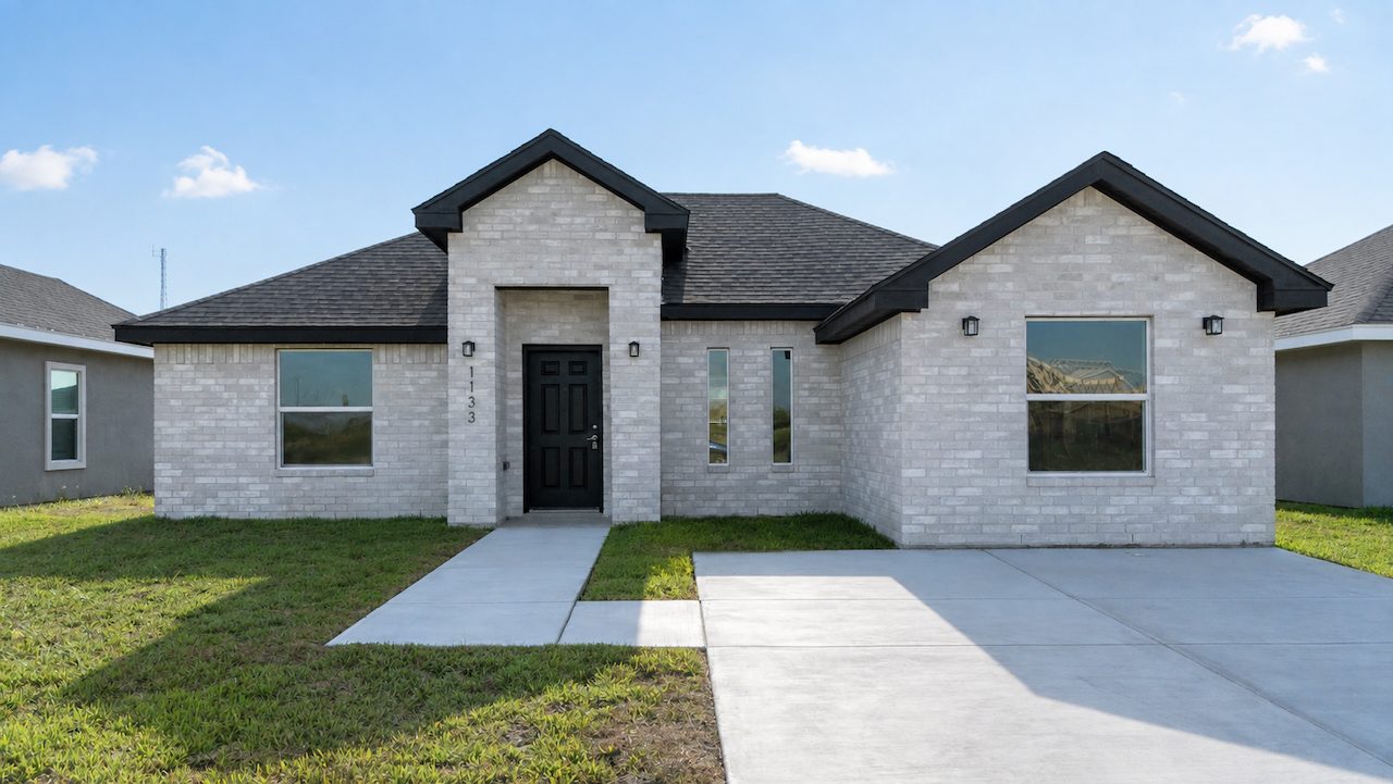 A newly built single-family brick home with a two-car driveway on the TX-4 corridor in Brownsville, Texas