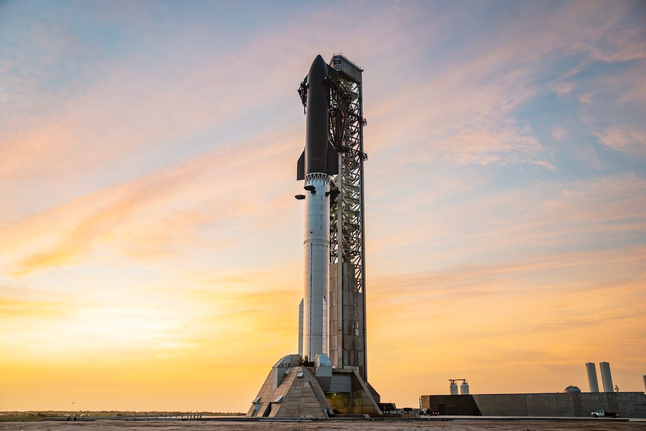 A SpaceX Starship vehicle stacked on the launch mount at Starbase in Cameron County, Texas, at sunrise